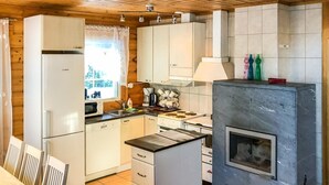 A compact kitchen with white cabinets, a Bosch refrigerator, a stove, and a built-in oven. - Vacation home Inkeri by Interhome (Jämsä)