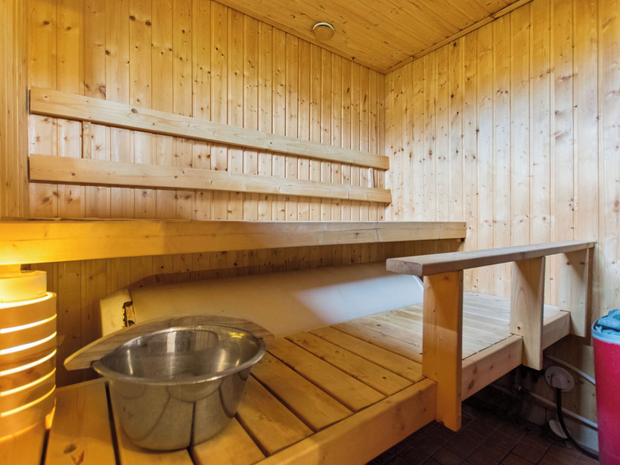A sauna room with wooden walls and benches.