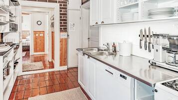 A kitchen with white cabinets, a stainless steel sink, and a coffee maker.