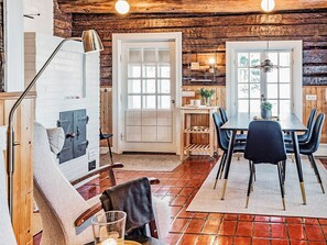 Ein rustikales Interieur mit Essbereich, Holzwänden und Kamin.
