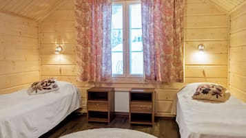 Una habitación con dos camas, un escritorio y una ventana con cortinas.
