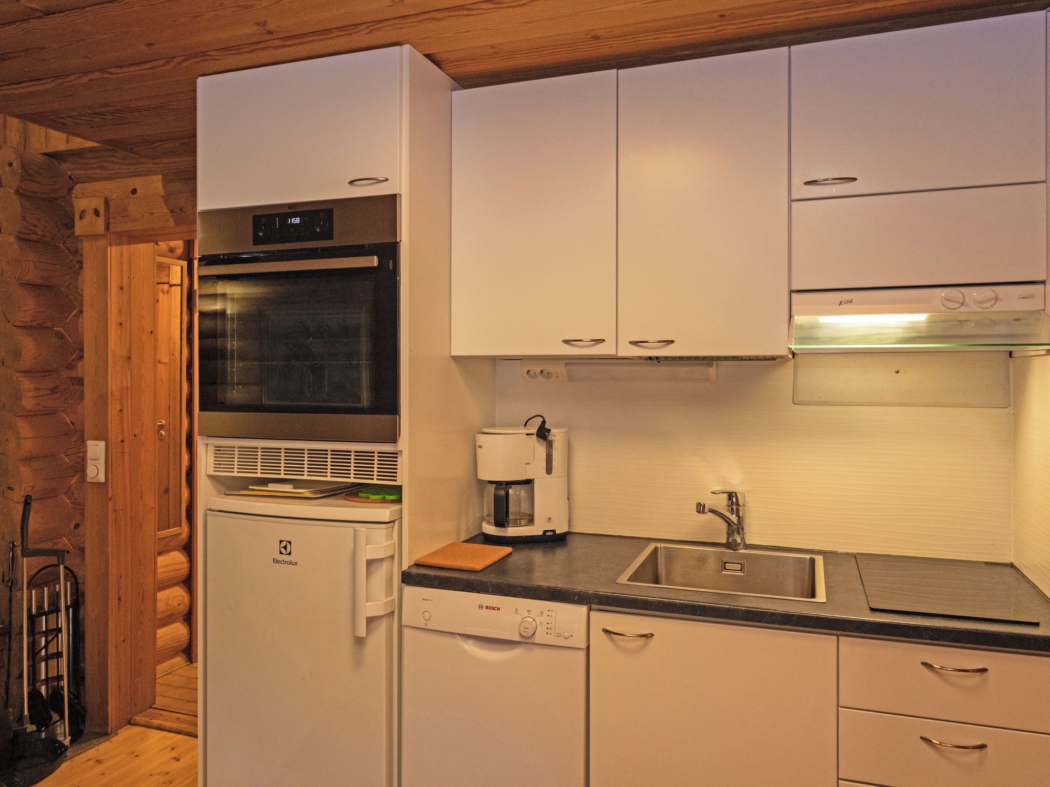 Una cocina compacta con horno integrado, microondas y cafetera.