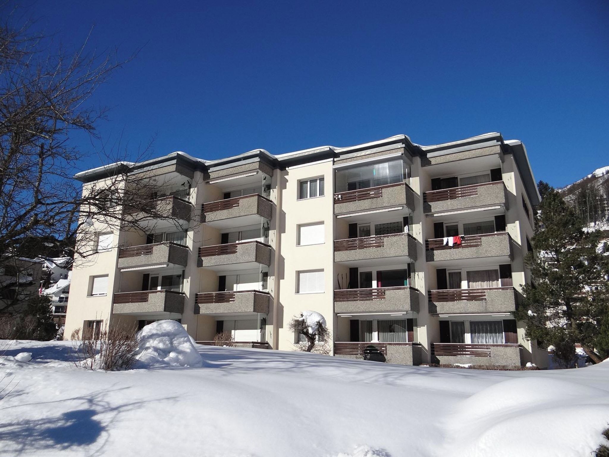 Ein mehrstöckiges Gebäude mit Balkonen, umgeben von Schnee.