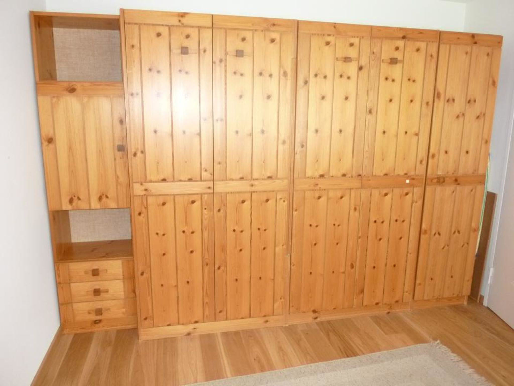Un armario de madera con varios compartimentos y una repisa incorporada.