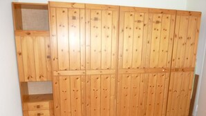 Une armoire en bois dotée de plusieurs compartiments et d’une étagère intégrée.