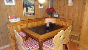 A wooden dining area with a central table, benches, and chairs. - Steinacher 7 Appartement/Fewo 4-Bettwohnung by Interhome (Engelberg)