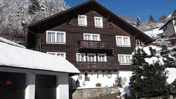 A traditional chalet-style building with multiple windows and a balcony, surrounded by snow-covered trees. - Steinacher 7 Appartement/Fewo 4-Bettwohnung by Interhome (Engelberg)