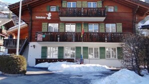 A wooden building with a balcony and a sign that reads "Teeboy". - Teleboy by Interhome (Lenk)