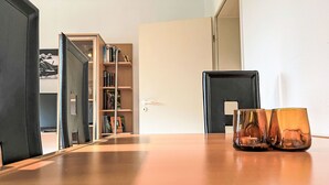 Une pièce avec une table en bois, une bibliothèque et une porte.