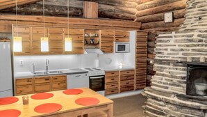 A modern kitchen with wooden cabinets, a stone wall, and a built-in microwave.