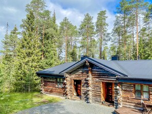 A log cabin with a sloped roof, surrounded by tall pine trees. - Rantaruka 4d1 by Interhome (Kuusamo)