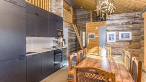 A modern kitchen with dark cabinets and a wooden dining table with chairs.