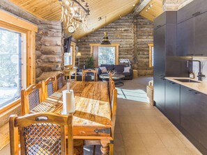 A log cabin interior with a dining area, sofa, and kitchen. - Muuttohaukka by Interhome (Kuusamo)