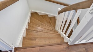 Eine Holztreppe mit weißen Geländern und einem Holgeländer.