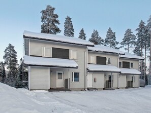 A two-story building with a covered porch and a garage. - Vuokatinlampi 7 a by Interhome (Sotkamo)