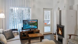 Ein Wohnzimmer mit Kamin, Fernseher und einer Couch.