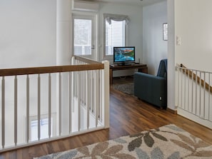 Un escalier avec une rampe en bois menant à un palier.