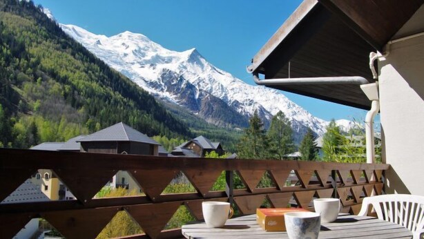 A wooden deck with a table and chairs overlooking a mountain range. - Gentiane by Interhome (Chamonix)