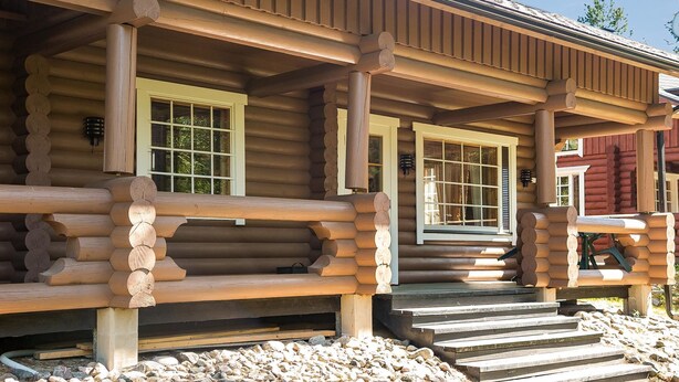 A log cabin with a porch, wooden steps, and a window with a grid pattern. - Tahkon tikka by Interhome (Nilsiä)