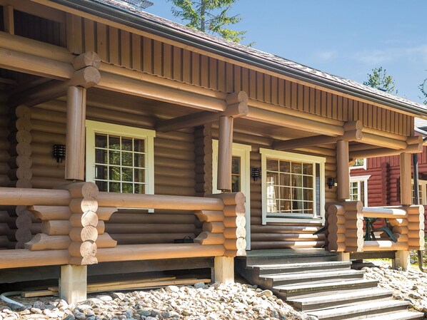 A log cabin with a porch, wooden steps, and a window. - Tahkon tikka by Interhome (Nilsiä)