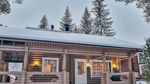 A log cabin with a porch, a front door, and a staircase leading up to the entrance. - Tahkon tikka by Interhome (Nilsiä)