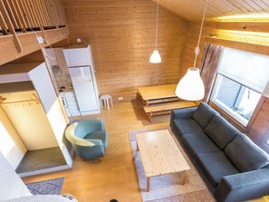 A compact living space with a kitchenette, a sofa, a dining table, and a chair.
