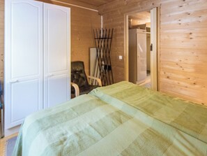 A room with a bed, a chair, and a wardrobe.