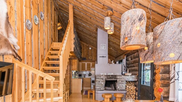 Un intérieur en bois avec un escalier, une cheminée et un coin repas.