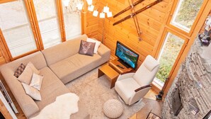 A cozy living room with a sectional sofa, a single armchair, a TV, and a fireplace. - Vuosseli-kelkka 15a by Interhome (Kuusamo)