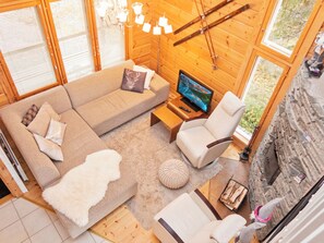 A cozy living room with a sectional sofa, a television, and a fireplace. - Vuosseli-kelkka 15a by Interhome (Kuusamo)