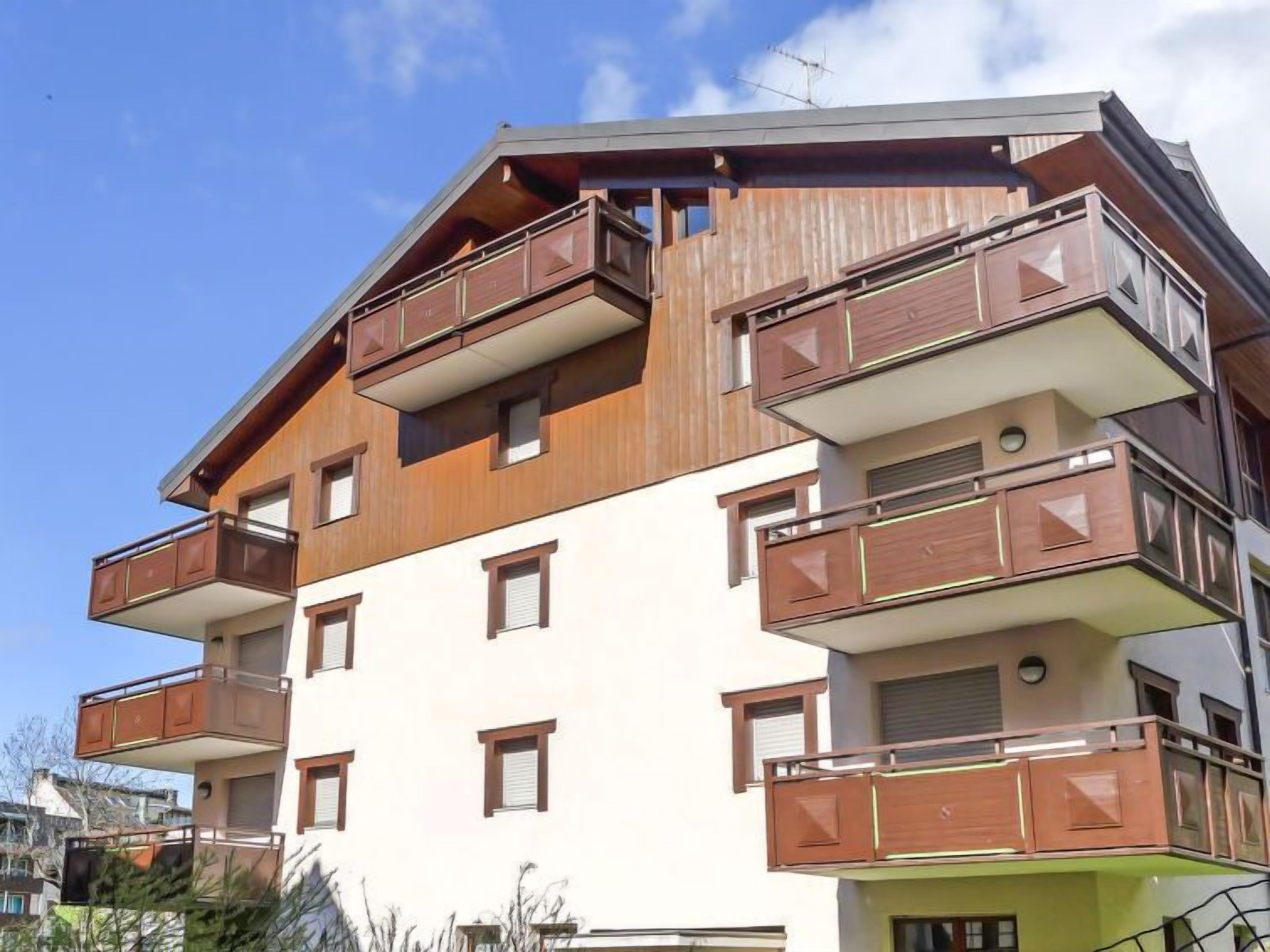 Un edificio de varios pisos con balcones, techo plano y cielo despejado.