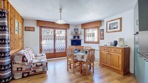 Un salon confortable avec un canapé, une table à manger, des meubles en bois et un téléviseur.