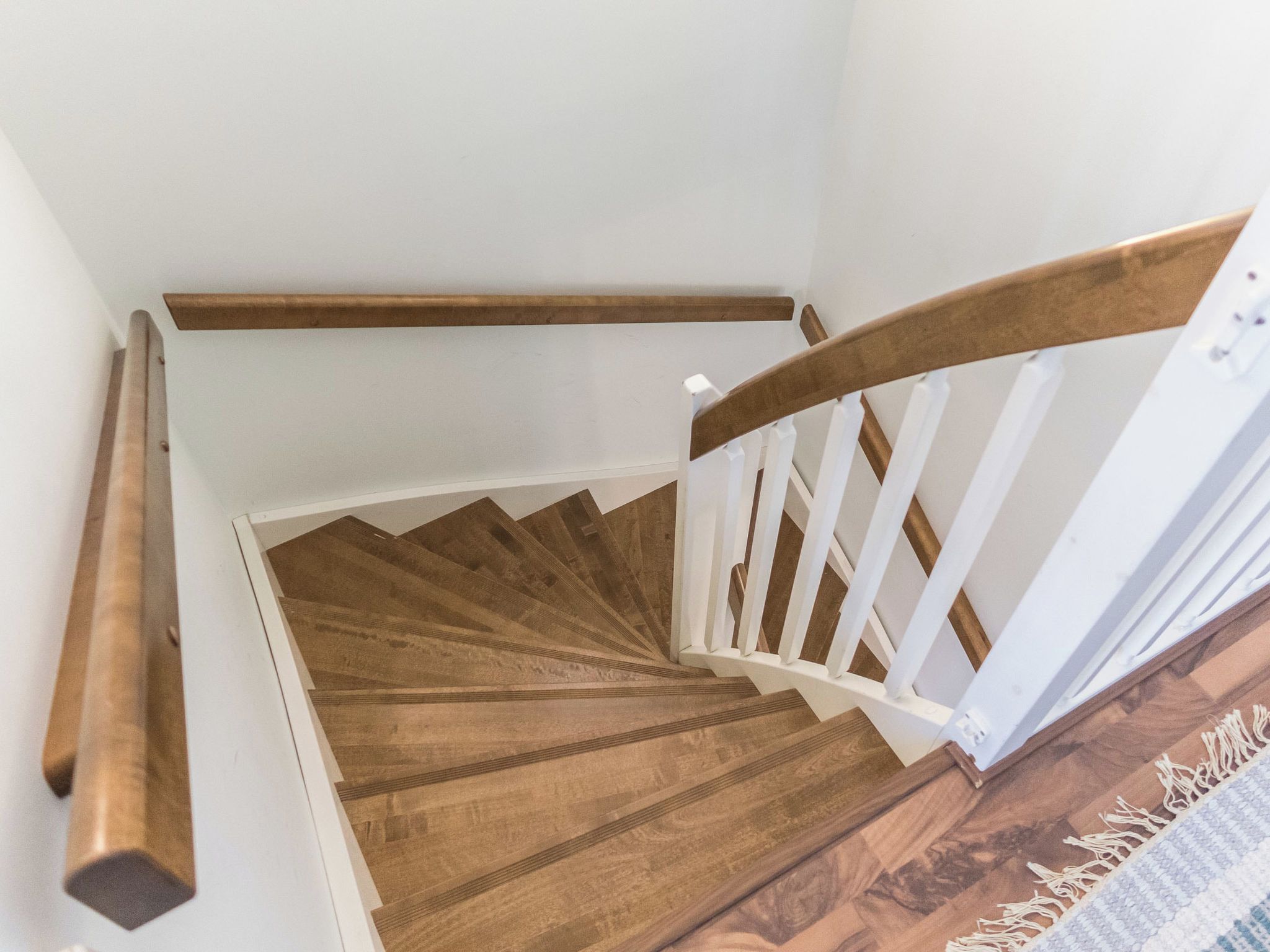 Una escalera de madera con barandas y pasamanos blancos.