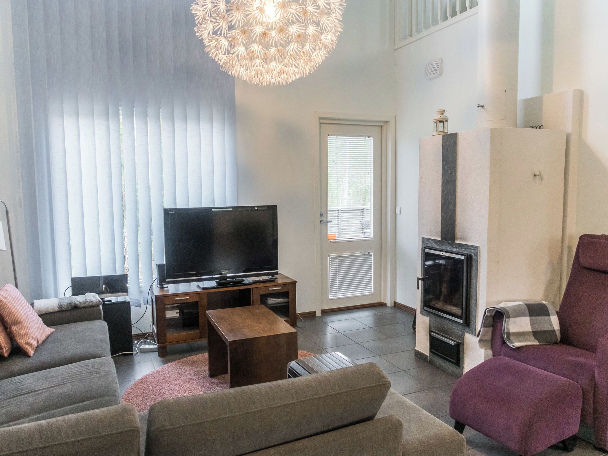 A living room with a flat-screen TV, a sofa, a coffee table, and a fireplace.