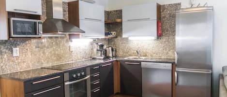 Een moderne keuken met een roestvrijstalen koelkast, een ingebouwde oven, magnetron en vaatwasser.