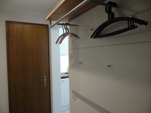 Une salle de bain avec une porte en bois, un porte-serviettes et un espace douche.