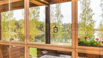 Una cabaña de madera con vista a un lago y árboles.