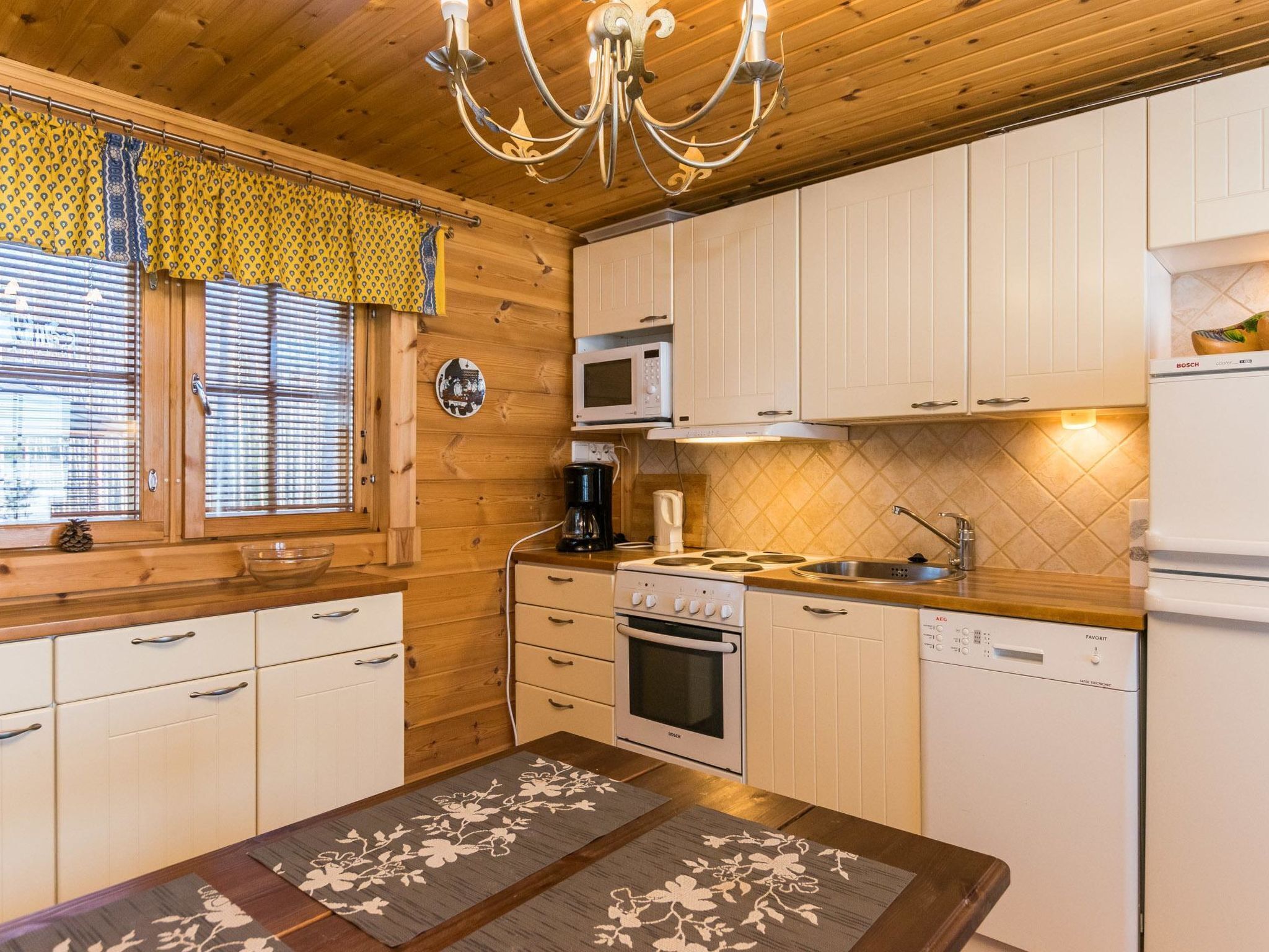 Een koelkast, een magnetron, een vaatwasser, kookgerei, borden en bestek