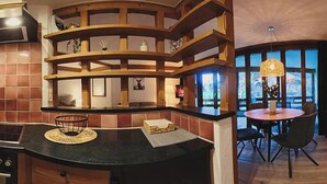 Una cocina con armarios de madera, una estufa y un comedor con mesa y sillas.