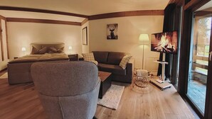 Una sala de estar acogedora con un sofá, un sillón, un televisor y una chimenea.