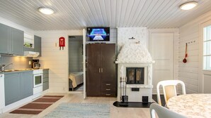 Een kleine keuken met moderne apparatuur, een open haard en een televisie.
