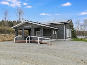 Un bâtiment portant une enseigne avec le nom « SAVUHOVI » et une entrée couverte avec des marches.