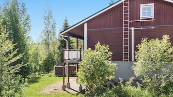 Ein rotes Holzgebäude mit einer überdachten Veranda und einer Leiter an der Seite.