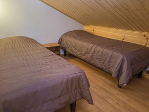 A small, single-room accommodation with two single beds, wooden flooring, and a sloped ceiling. - Tintintupa by Interhome (Nilsiä)