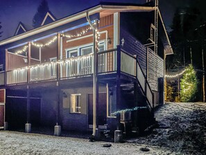 A two-story house with a balcony, string lights, and a snowy ground. - Tintintupa by Interhome (Nilsiä)