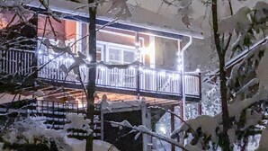 A snow-covered balcony with railings, a staircase, and a building in the background. - Tintintupa by Interhome (Nilsiä)