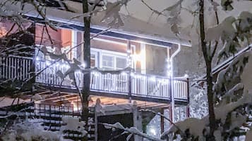 Ein Gebäude mit Balkon, umgeben von schneebedeckten Bäumen.