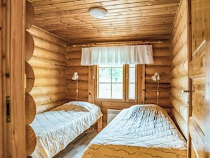 A cabin with two beds, a window with blinds, and a ceiling light. - Kieppi b by Interhome (Kuusamo)