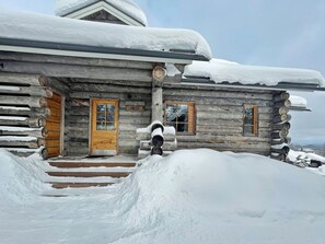 A log cabin with a wooden door and window shutters, surrounded by snow. - Alte ruka by Interhome (Kuusamo)