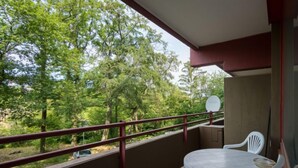 A balcony with a table and chairs, a view of trees, and a satellite dish. - Wanderlust (B212) by Interhome (Lahnstein (Koblenz))